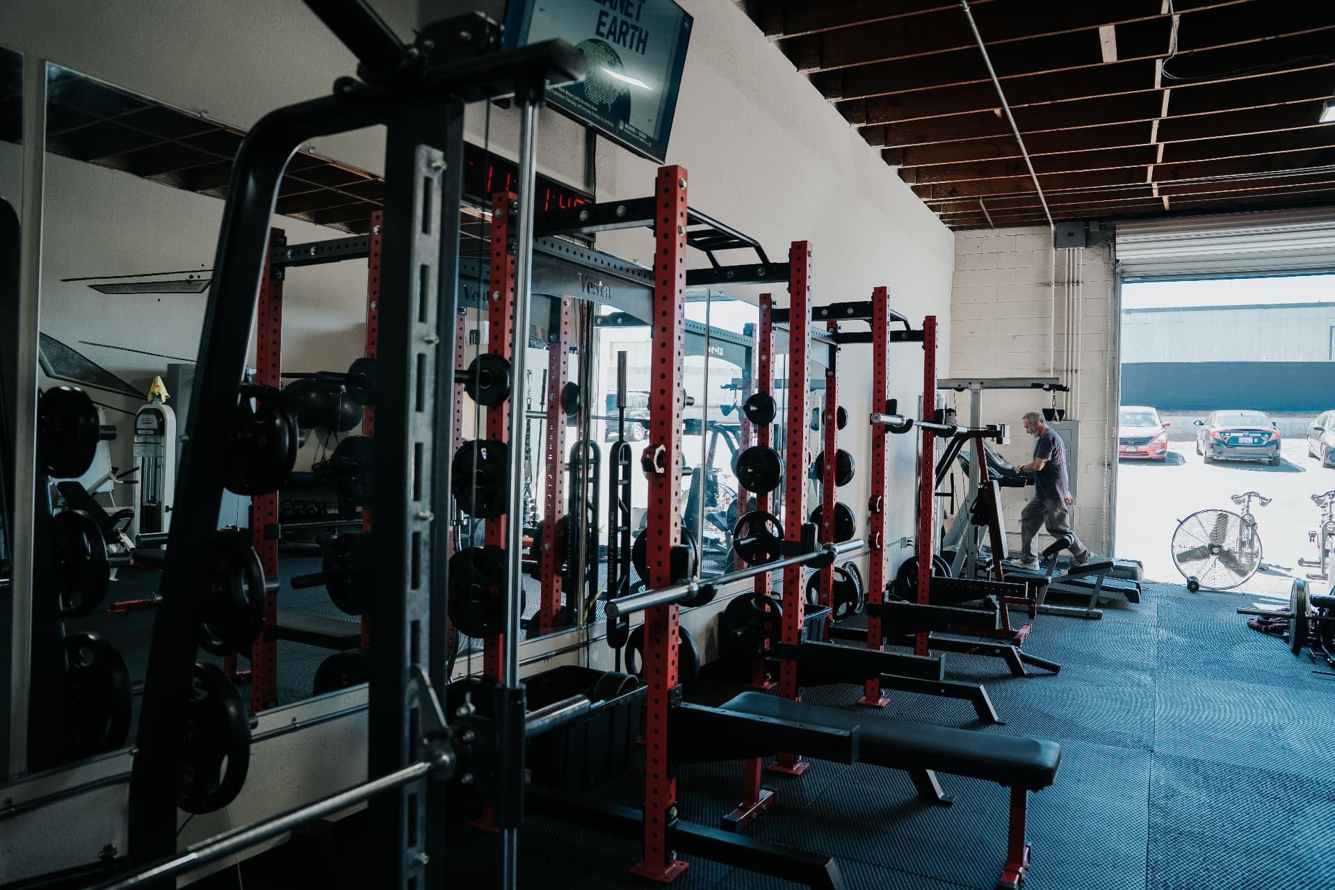 LionStrong Athletics strength floor with red racks and open garage door